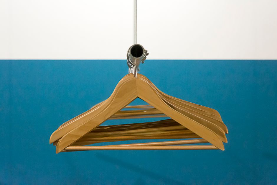 Stylish arrangement of wooden hangers hanging in front of a blue and white backdrop.