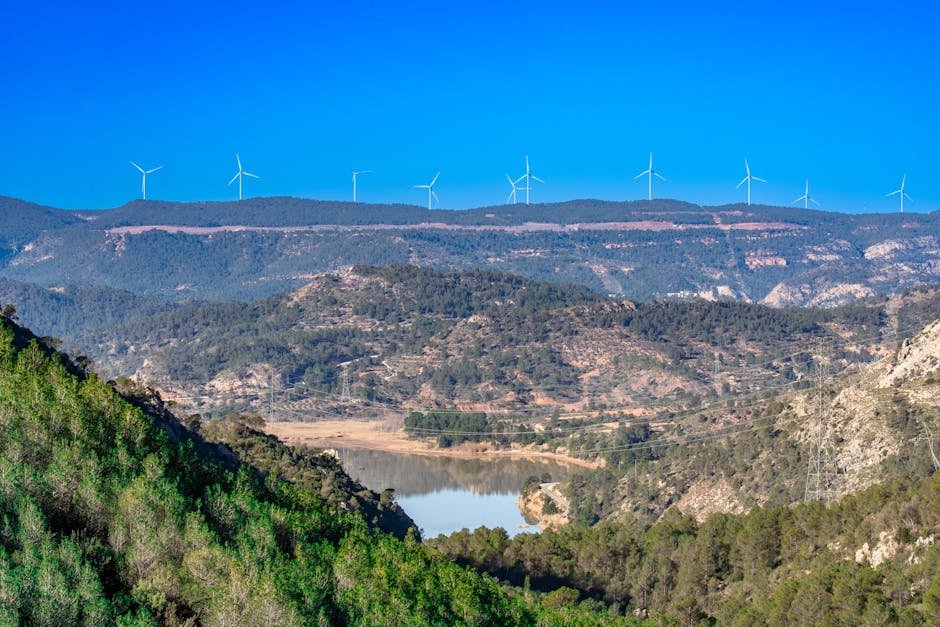 Picturesque landscape of a wind farm in Cofrentes, Spain with lush greenery and clear blue sky.