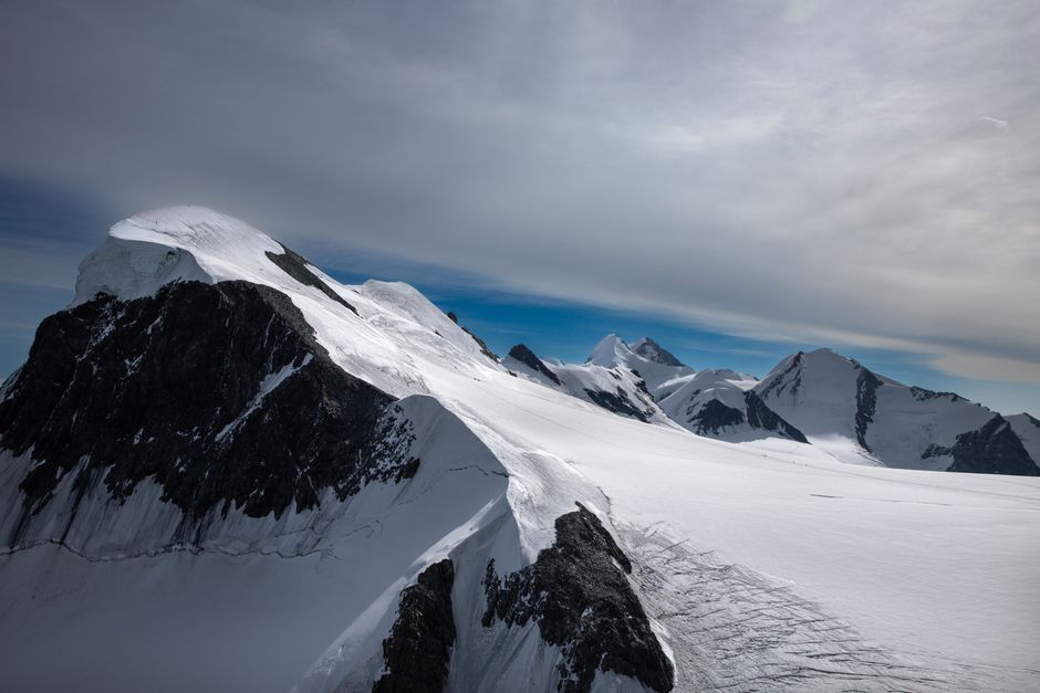 Majestic snow-covered peaks of Zermatt under a cloudy sky, epitomizing alpine beauty.