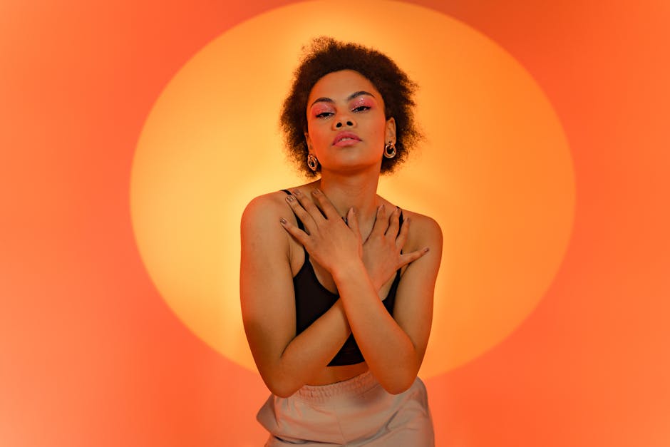 Fashionable portrait of a stylish model against a vivid orange background.