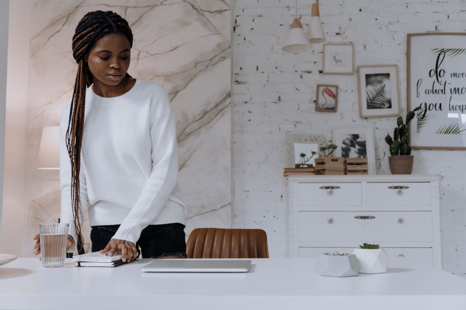 Businesswoman working with laptop and notebook in a chic home office setting.