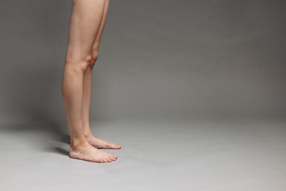 Studio shot of bare legs against a gray backdrop, focused on minimalist design.